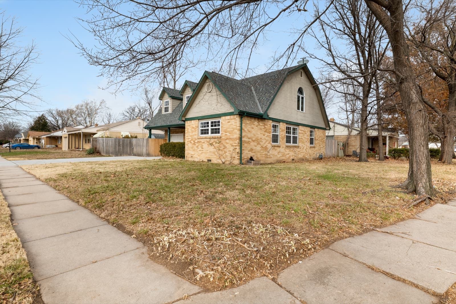 Brick and stucco cottage-style house on a corner lot